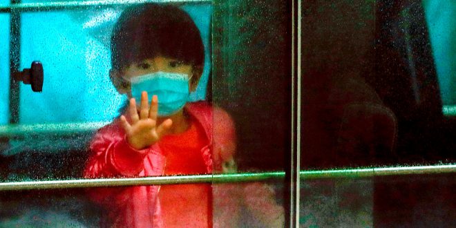 A child waves as she sits in a vehicle carrying residents evacuated from a public housing building, following the outbreak of the novel coronavirus, outside Hong Mei House, at Cheung Hong Estate in Hong Kong, China February 11, 2020. REUTERS/Tyrone Siu     TPX IMAGES OF THE DAY